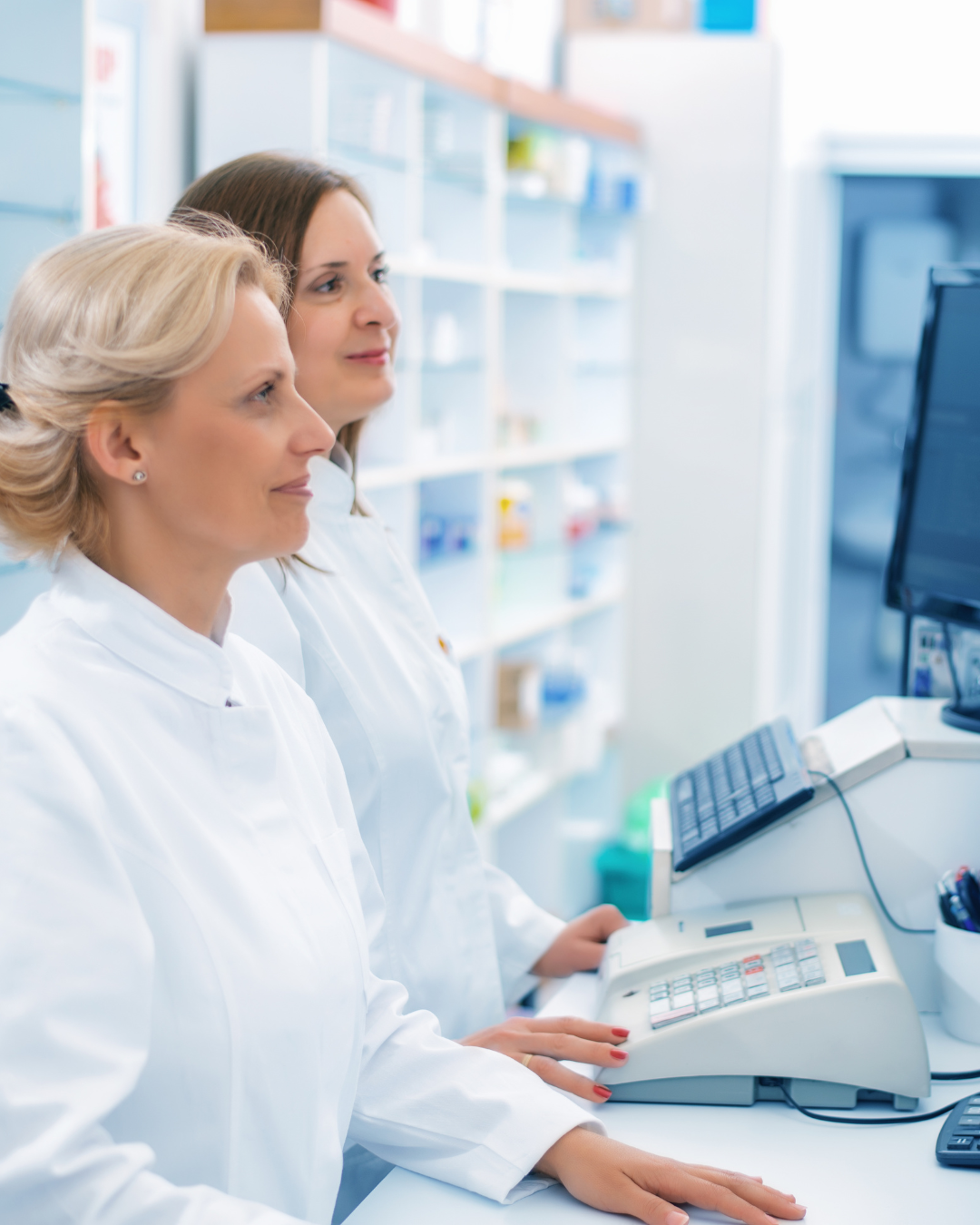 Two pharmacists working together at the pharmacy counter.