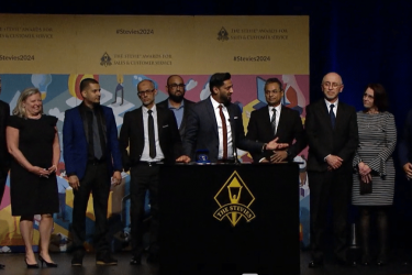 An image of Samir Haleem giving an acceptance speech at The Stevies.