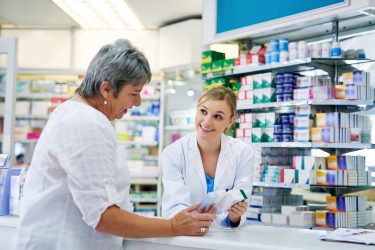 Pharmacist explaining medicine to a woman in the pharmacy for pharmaceutical healthcare prescription.