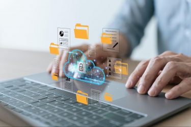 Hands using a laptop with a digital cloud security icon surrounded by floating document and folder graphics.