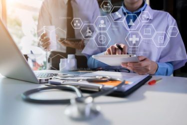 The medical team uses tablet technology. Laptop computer To study drug type information and writing a patient report on the office desk.